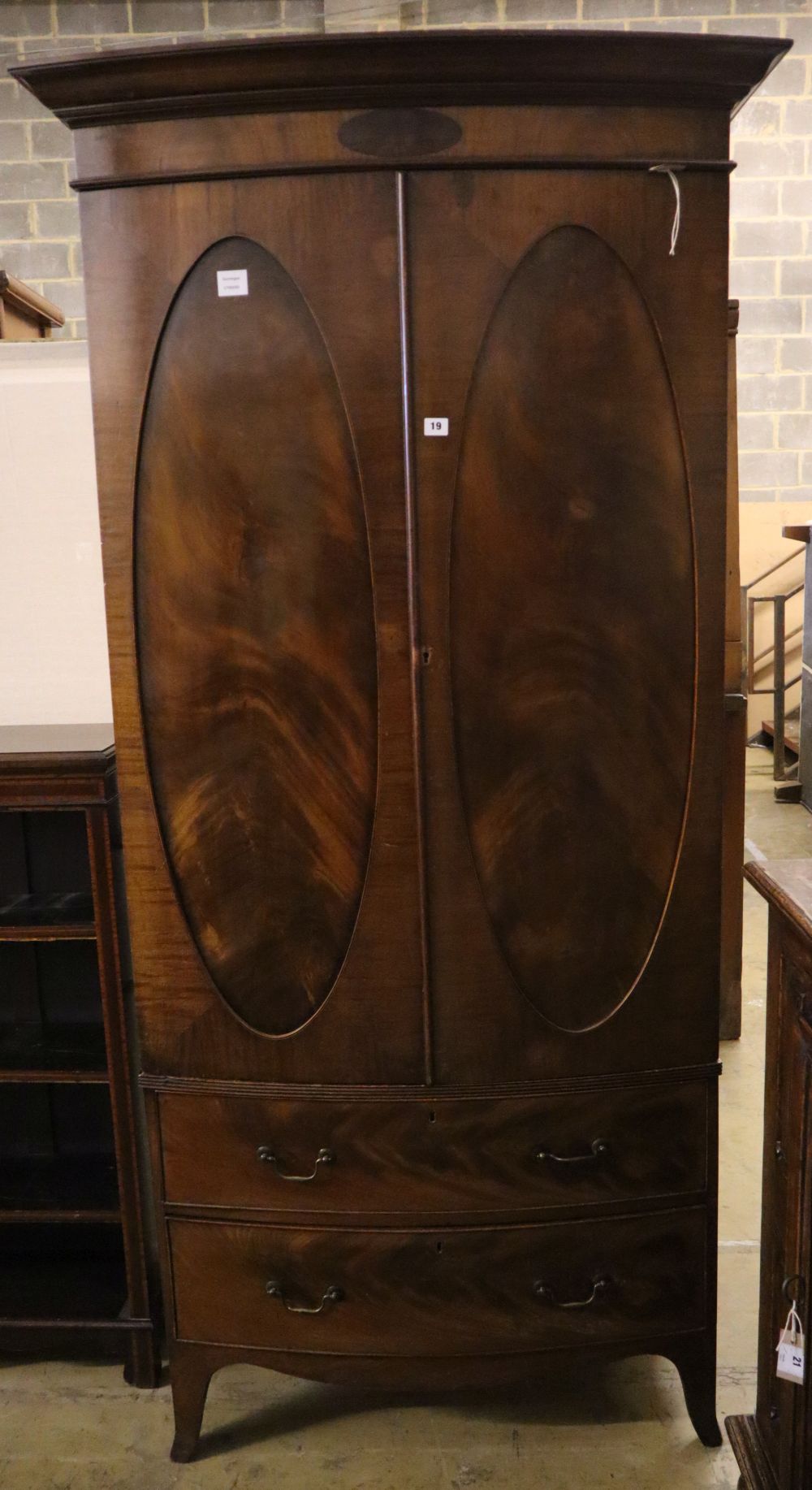 A 1920s George III style mahogany bow front wardrobe with two drawers, with key, width 102cm depth 54cm height 208cm